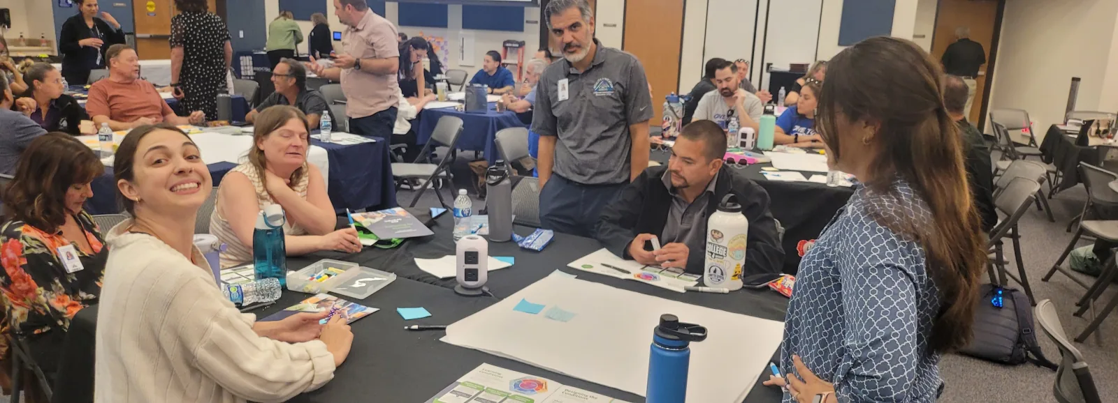District leaders discussing a sticky-note poster at a planning table